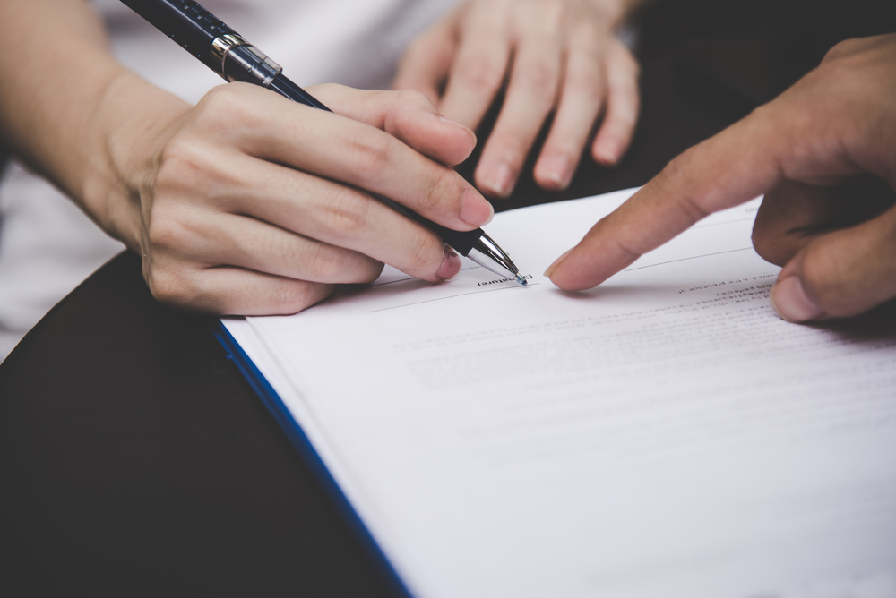person signing a personal injury settlement release form