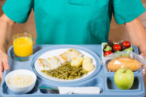 hospital worker holding food tray