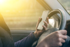 person driving while looking at their phone before a car accident 